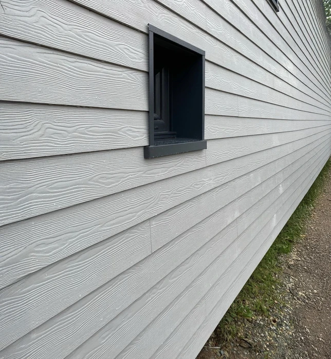 Façade extérieure de bâtiment avec bardage horizontal en lames composites grises à texture bois
