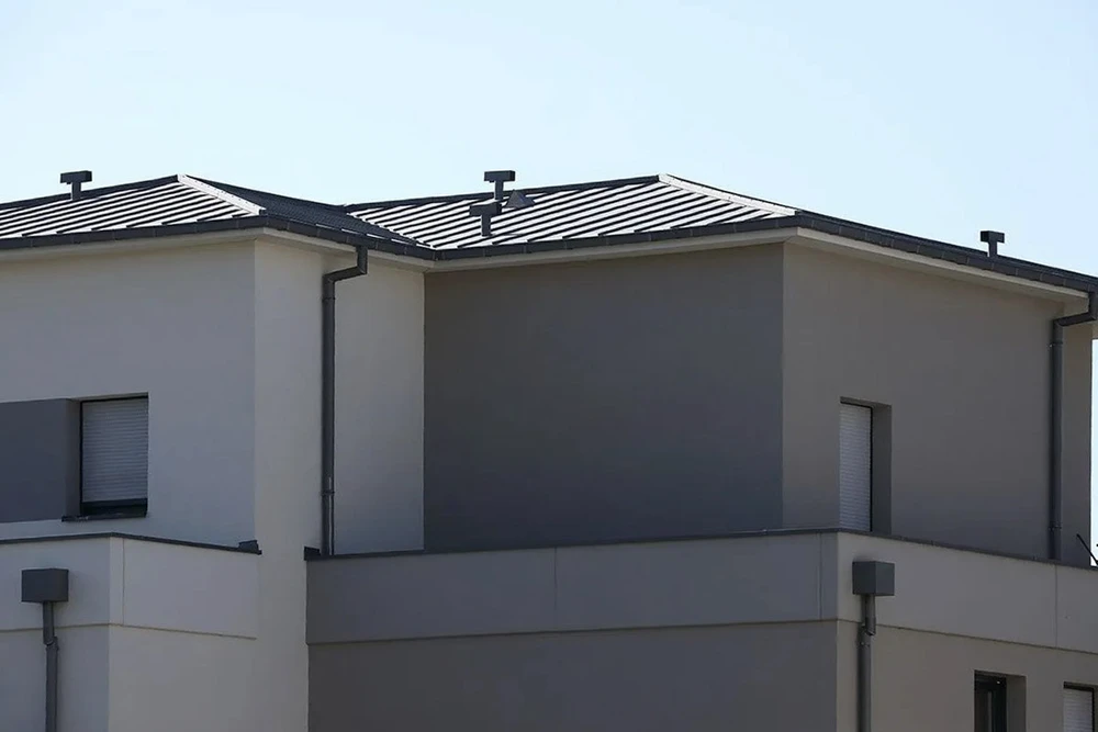 Façade extérieure d'une maison moderne à deux niveaux avec toiture métallique à bac acier nervuré