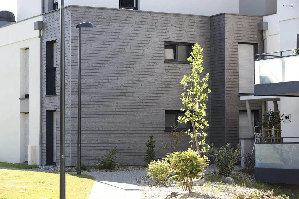 Chantier de construction extérieur avec ouvriers installant une charpente en bois