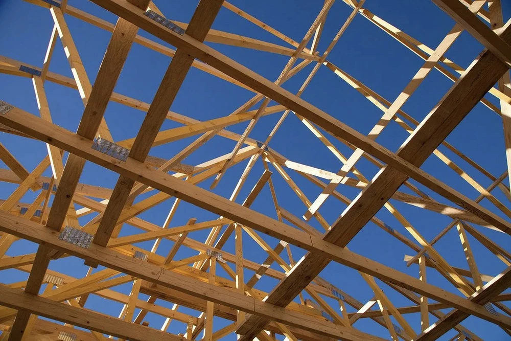 Chantier de construction extérieur avec ouvriers installant une charpente en bois