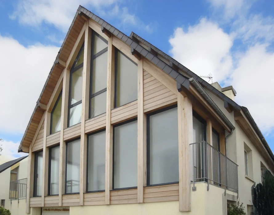 Façade d'immeuble résidentiel moderne avec bardage bois horizontal gris et sections blanches