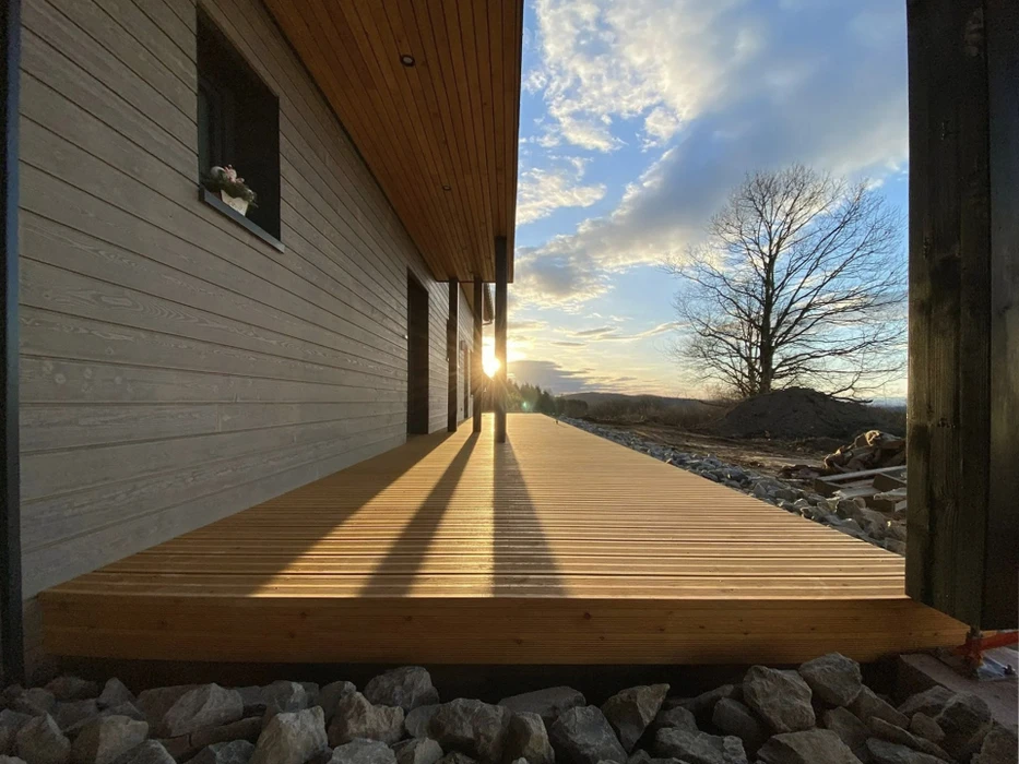 Chantier de construction en extérieur avec charpentiers travaillant sur une structure de toit complexe