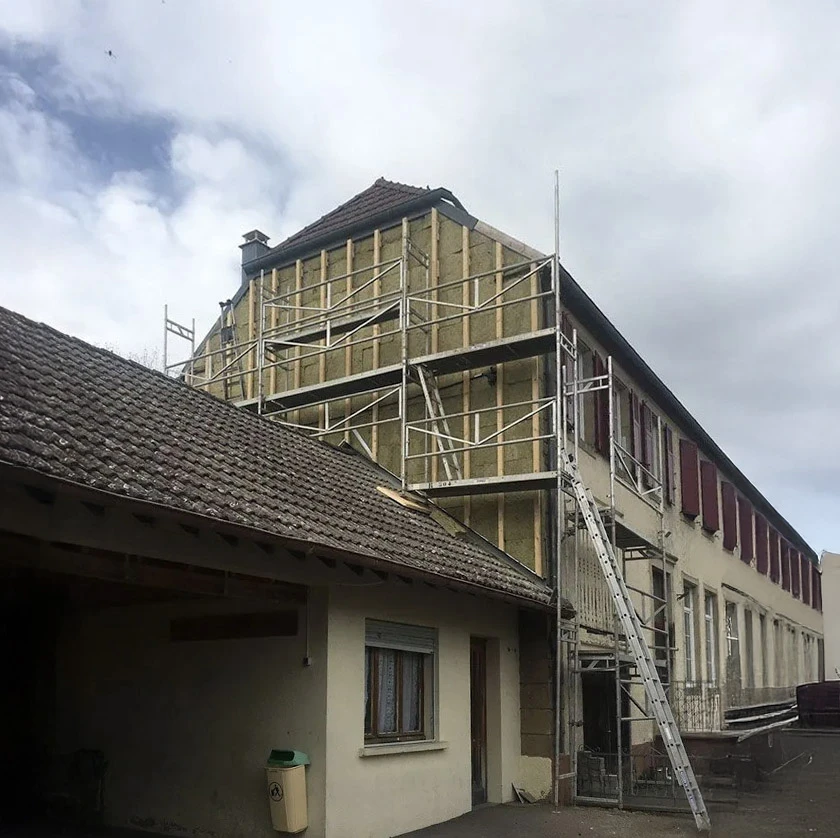 Façade extérieure de bâtiment avec bardage horizontal en lames composites grises à texture bois