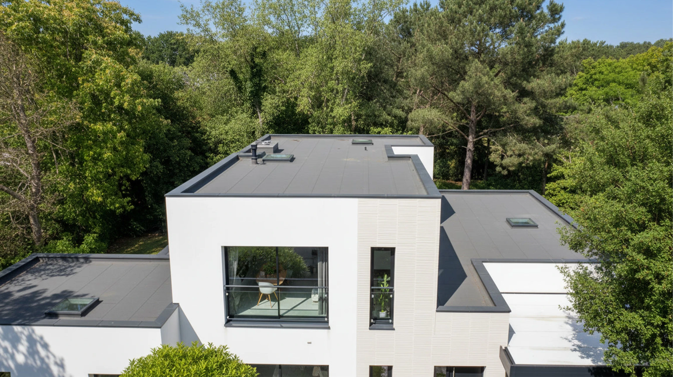 Toiture commerciale plate avec membrane d'étanchéité bitumineuse, système de drainage et éléments techniques